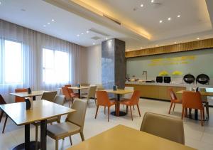 City Comfort Inn Jingzhou Hongxing Road Food Street في Shashi: مطعم مع طاولات وكراسي ومطبخ