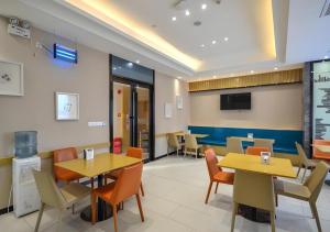 City Comfort Inn Jingzhou Hongxing Road Food Street في Shashi: غرفة طعام مع طاولات وكراسي وتلفزيون