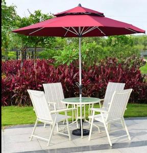 een tafel met vier stoelen en een rode paraplu bij Departamento tipo mediterraneo in Hermosillo +12 foto's