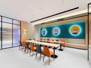 City Comfort Inn Wuhan International Expo Center Qianjin Village Metro Station في ووهان: غرفة مؤتمرات بها طاولة طويلة وكراسي