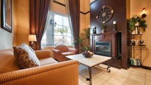 uma sala de estar com um sofá e uma lareira em Best Western Route 66 Glendora Inn em Glendora