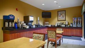 un restaurante con un bar con mesas y sillas en Best Western PLUS Fresno Inn, en Fresno