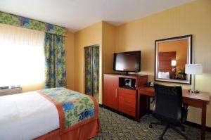 Habitación de hotel con cama, escritorio y TV. en Best Western PLUS Fresno Inn, en Fresno