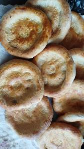 a pile of donuts sitting on top of a table at Nurdin Guest House in Kashkaldak