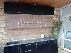 a kitchen with a sink and wooden cabinets at Nurdin Guest House in Kashkaldak +8 photos