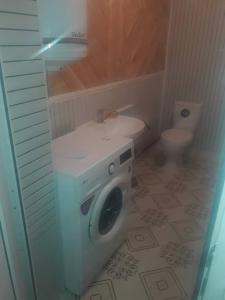 a washing machine in a bathroom with a toilet at Nurdin Guest House in Kashkaldak