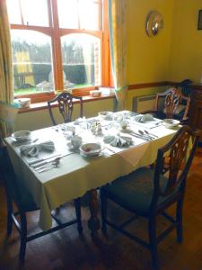 a dining room table with a white tablecloth on it at Littlebridge House in Bromyard