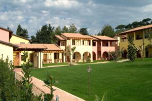 rząd domów z zielonym trawnikiem w obiekcie Le Corti Del Sole Residence w mieście Venturina Terme