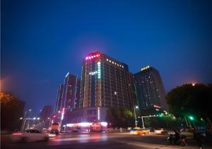 Un edificio alto con luces rojas por la noche. en City Comfort Inn Yichang Dongshan Three Gorges University Shuiyuecheng, en Yichang