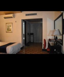 a hotel room with a bed and a desk at Alsafina in Lahore