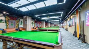 a row of pool tables in a billiard room at James Joyce Coffetel Tianjin Railway Station in Tianjin