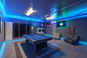 eine Tischtennisplatte in einem Raum mit blauem Licht in der Unterkunft Fresh & Fun! Vegas 4BR w Heated Pool, Dog Friendly in Las Vegas + 28 Fotos