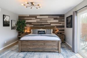 Schlafzimmer mit einer Wand mit Holzakzenten und einem Bett in der Unterkunft Fresh & Fun! Vegas 4BR w Heated Pool, Dog Friendly in Las Vegas