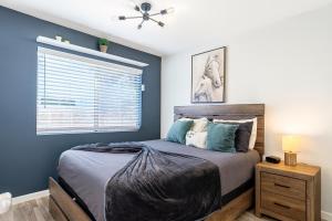 ein Schlafzimmer mit einem Bett mit blauen Wänden und einem Fenster in der Unterkunft Fresh & Fun! Vegas 4BR w Heated Pool, Dog Friendly in Las Vegas