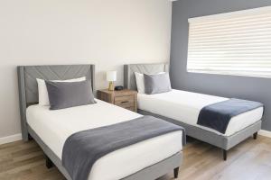 ein Schlafzimmer mit zwei Betten und einem Fenster in der Unterkunft Fresh & Fun! Vegas 4BR w Heated Pool, Dog Friendly in Las Vegas