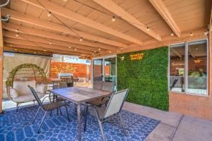 a patio with a table and chairs and a green wall at ᨒོ The Good Life - Fun Pool Escape 15 min to Strip in Las Vegas