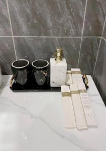 Un estante con dos tazas y una caja y una vela. en Private Villa by YUSETH Residence, en Phumĭ Ta Phŭl