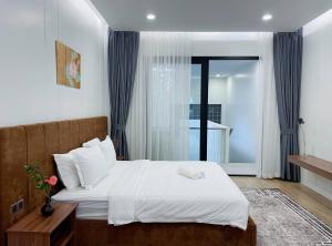 Un dormitorio con una cama con sábanas blancas y una ventana. en Private Villa by YUSETH Residence, en Phumĭ Ta Phŭl