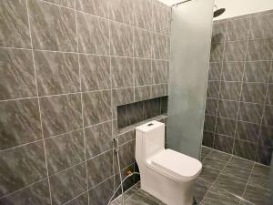 Un baño con inodoro y una pared de azulejos. en Private Villa by YUSETH Residence, en Phumĭ Ta Phŭl 28 fotos más