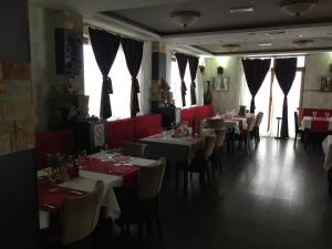 a dining room with tables and chairs and windows at G4 Apartment Milmari in Kopaonik