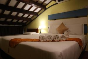 Un dormitorio con una cama grande con toallas. en The Lang Hoose, en George Town