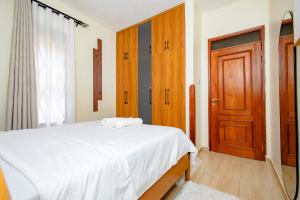 a bedroom with a bed and a wooden door at The Cozy Nest in Kampala