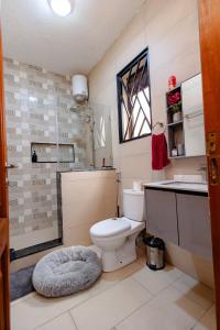 a bathroom with a toilet and a sink at The Cozy Nest in Kampala +27 photos