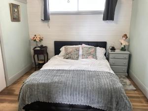 a bedroom with a bed and a dresser and a window at Fortuna views farm stay in Jumbuk