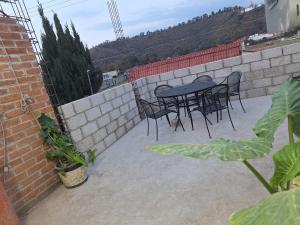a patio with a table and chairs on a brick wall at 3- Departamento con terraza in Amecameca de Juárez