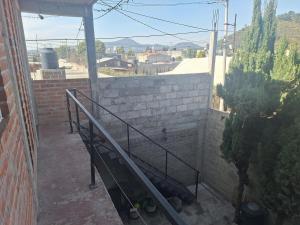 a stairway leading to a building with a brick wall at 3- Departamento con terraza in Amecameca de Juárez