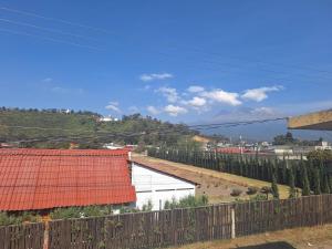 a fence in front of a white building with trees at 3- Departamento con terraza in Amecameca de Juárez