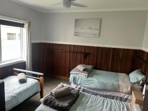 a bedroom with three beds and a ceiling fan at Bemm River Bungalows - Bellbird Abode - Bungalow 1 in Bemm River