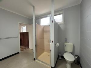 a bathroom with a toilet and a walk in shower at Bemm River Bungalows - Bellbird Abode - Bungalow 1 in Bemm River +9 photos