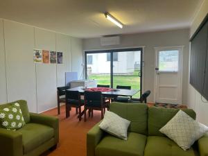 a living room with a green couch and a table at Bemm River Bungalows - Bellbird Abode - Bungalow 1 in Bemm River