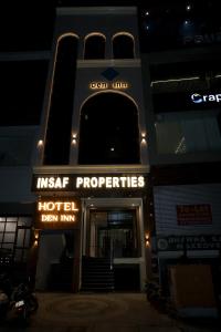 a hotel sign in front of a building at night at Den Inn in Hisār