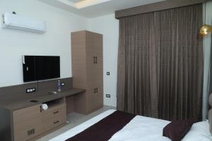 a bedroom with a bed and a television in it at Den Inn in Hisār +16 photos