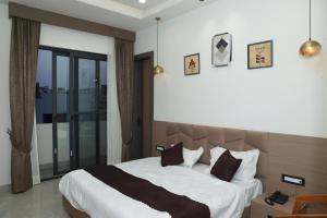 a bedroom with a large bed and a large window at Den Inn in Hisār
