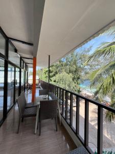 Tropica Gili Hotel - Gym & Recovery Spa في غيلي تراوانغان: غرفة طعام مع طاولة وكراسي على شرفة