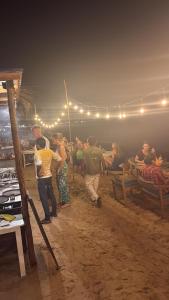 a group of people standing on the beach at night at Hotel Surf Resort in Arugam Bay +69 photos