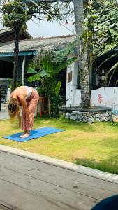 a woman doing a yoga pose on a yoga mat at Hotel Surf Resort in Arugam Bay