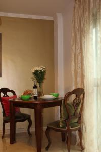 una mesa de comedor con 2 sillas y un jarrón de flores en Tiffany's Apartment, en Las Palmas de Gran Canaria