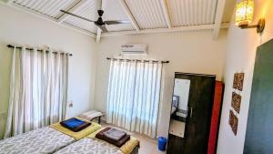 a bedroom with a bed and a ceiling fan at Redstone Hills, Diveagar in Diveagar