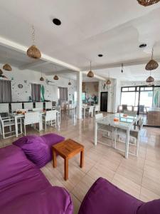 Tropica Gili Hotel - Gym & Recovery Spa في غيلي تراوانغان: غرفة معيشة مع أريكة أرجوانية وطاولة