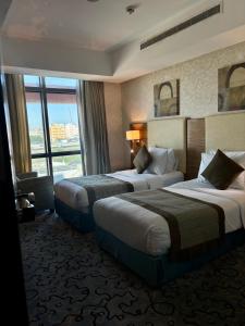 una camera d'albergo con due letti e una finestra di فندق الشهباء جده Al Shahba Jeddah a Gedda