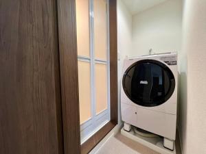 una lavatrice in una stanza accanto a una porta di Apartment Hotel in Katsushika City a Tokyo