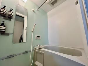 bagno con vasca e specchio di Apartment Hotel in Katsushika City a Tokyo Altre 15 foto