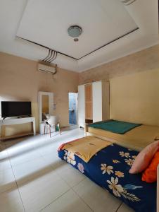 a bedroom with two beds and a flat screen tv at Chill-Inn near Surabaya Zoo Syariah in Surabaya
