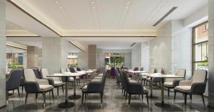 a dining room with tables and chairs and windows at Lavande Hotel Xuchang Pangdonglai Hengdajinhui Plaza in Xuchang