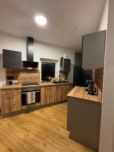 a large kitchen with wooden floors and a counter top at Apartment Almtal Liebe in Viechtwang