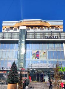 Taj Mahal Osh في أوش: مبنى كبير أمامه شجرة عيد الميلاد